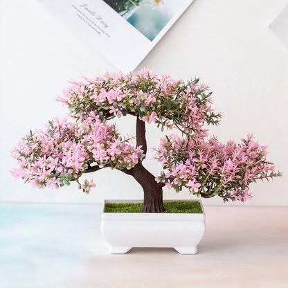 Artificial cherry blossom bonsai tree in a small pot on a shelf
